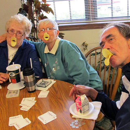 People with potato chip duck-bills playing cards